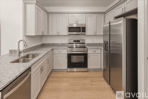 A kitchen with a stove, oven, sink, and refrigerator.