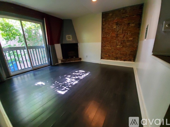 A room with a fireplace and wooden floors.