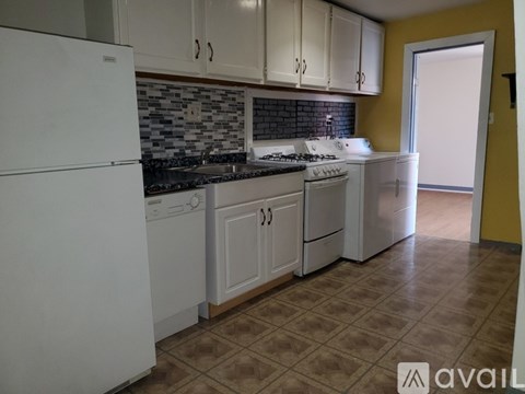 A kitchen with white appliances and cabinets.