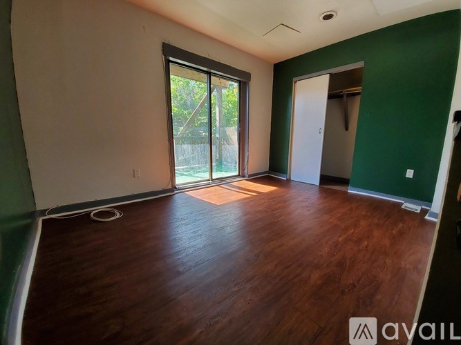 A room with wooden floors and a large window.