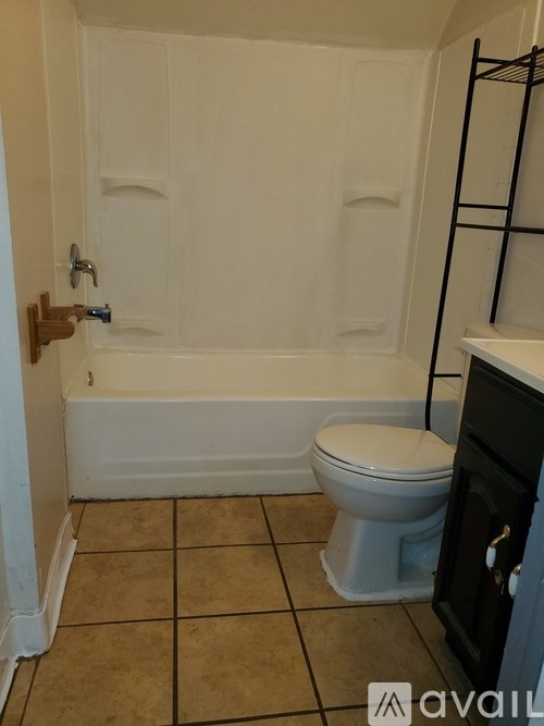 A bathroom with a toilet, tub, and sink.