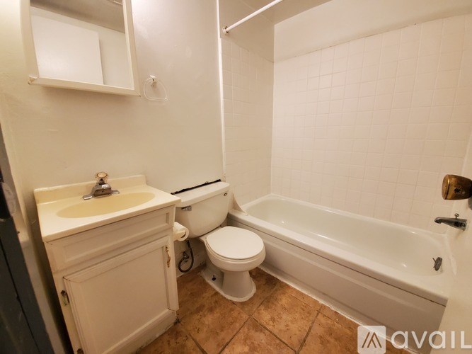 A white bathroom with a toilet, sink, and bathtub.