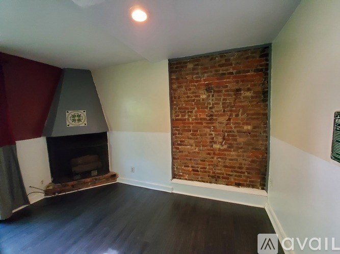 A room with a fireplace and a brick wall.