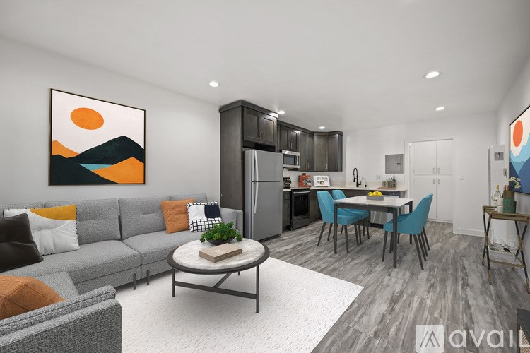 A modern living room with a grey sofa, a coffee table, and a dining table with chairs.
