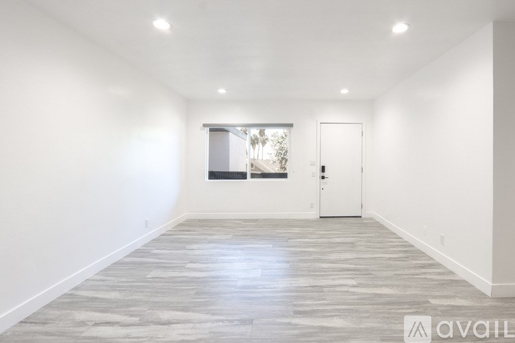 A spacious room with a grey floor and white walls.