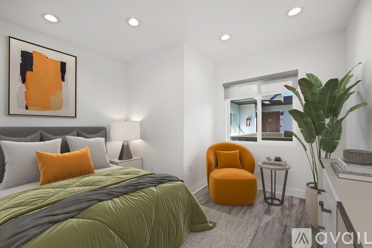 A bedroom with a bed, chair, and painting.