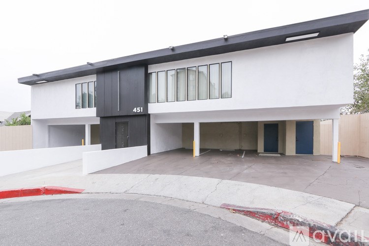 A modern two-story building with a black door and windows.