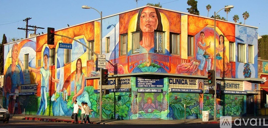 A mural on a building with a woman's face as the central figure.