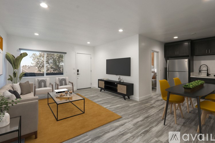 A modern living room with a black coffee table and a flat screen TV mounted on the wall.