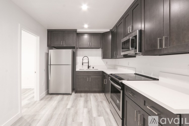 A kitchen with dark wood cabinets and a white refrigerator.