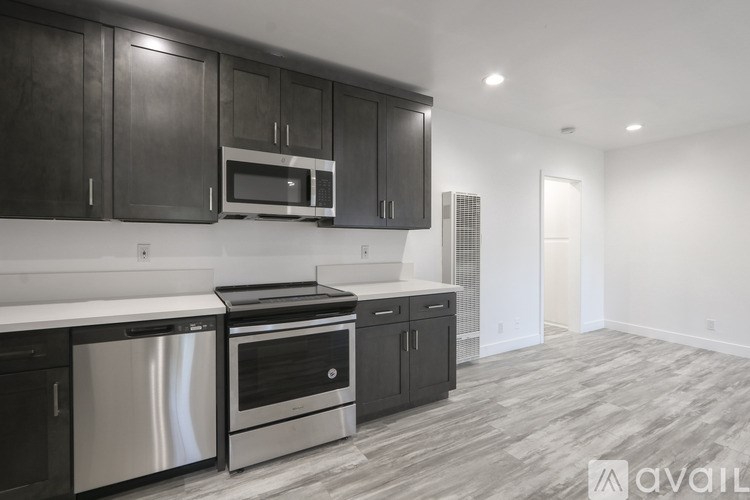 A modern kitchen with dark wood cabinets and stainless steel appliances.