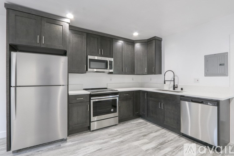 A modern kitchen with dark wood cabinets and stainless steel appliances.
