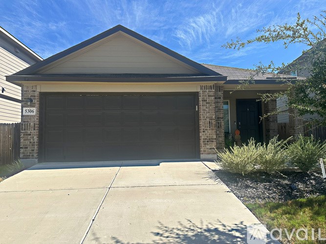 A house with a garage door and a driveway.
