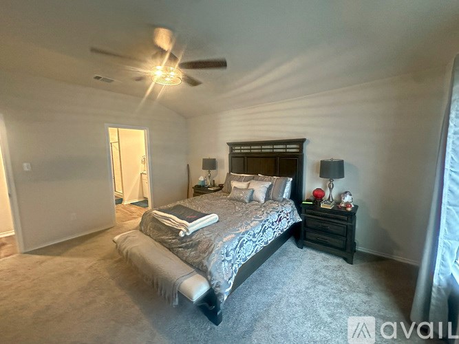 A bedroom with a bed, nightstand, and window.