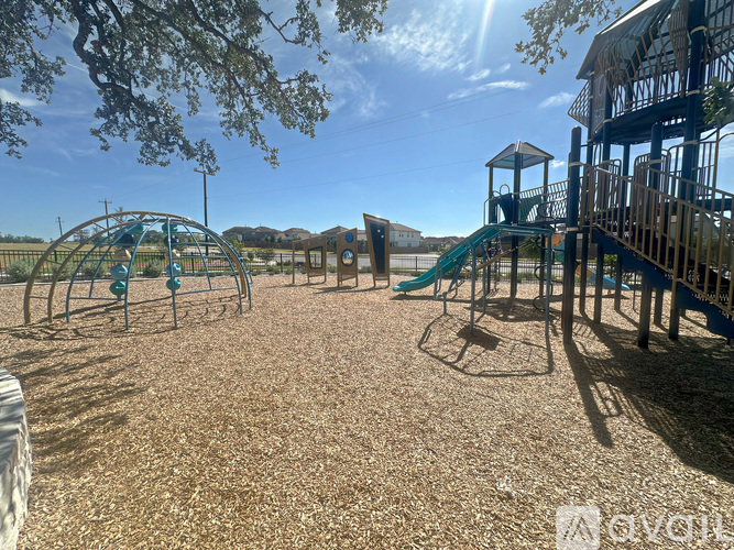 A playground with a green slide and a wooden structure.