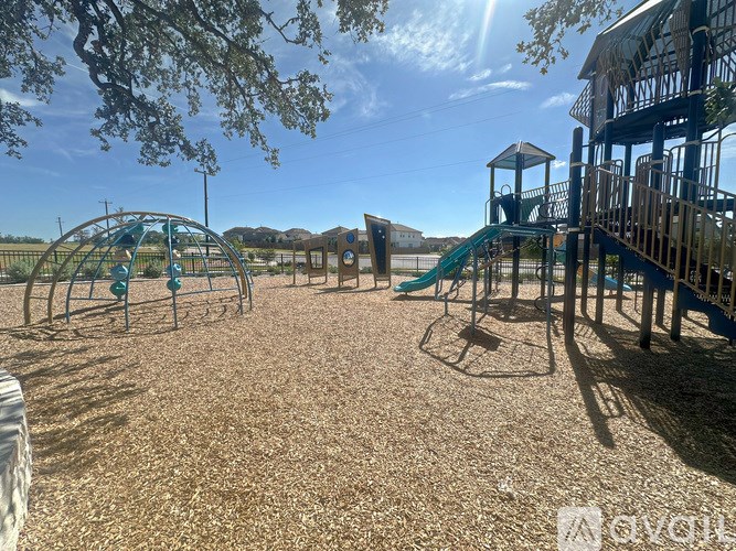 A playground with a green slide and a wooden structure.