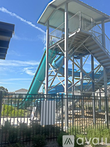 A water slide with a metal railing and a white roof.