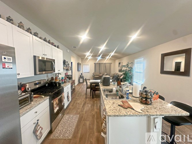 A kitchen with white cabinets and a stainless steel refrigerator.