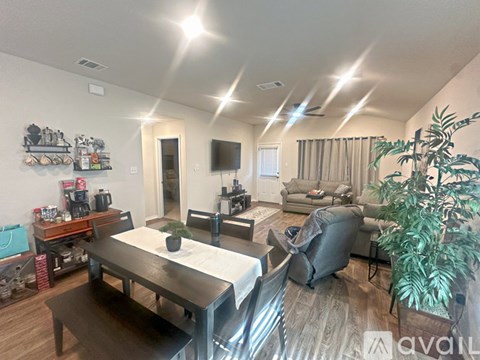 A well-lit living room with a dining table and chairs.