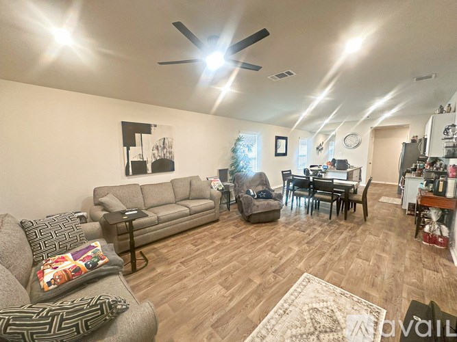 A living room with a grey couch and a wooden floor.