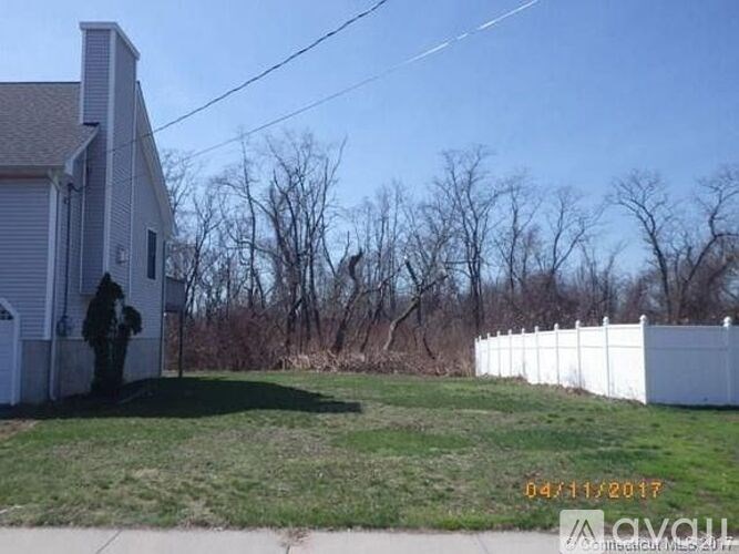 A house with a white fence and a person standing in front of it.