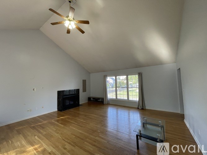 A room with a fireplace and a ceiling fan.