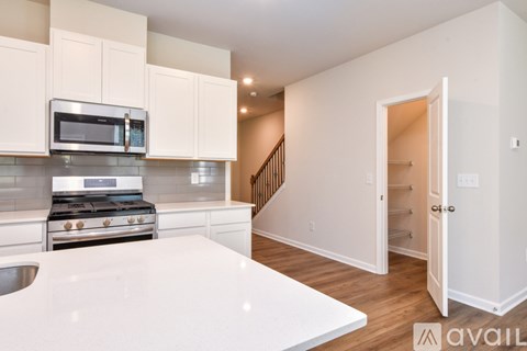 A kitchen with white cabinets and a stainless steel stove top.