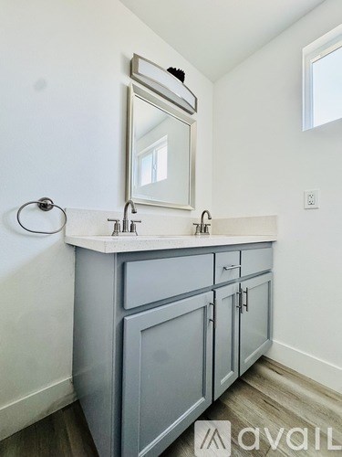 A bathroom with a white countertop and a grey cabinet.