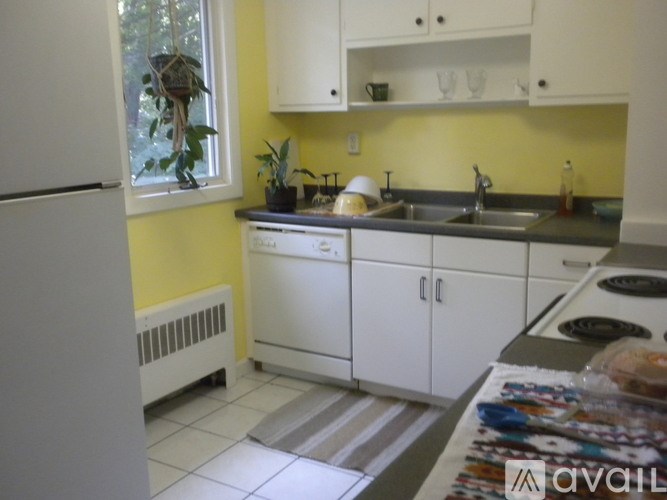 A kitchen with white cabinets and a white refrigerator.