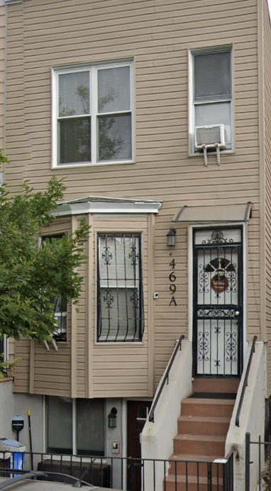 A two story house with a black gate and a white door.