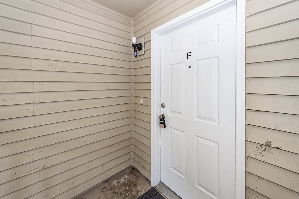 A white door with a keyhole and a key in it.