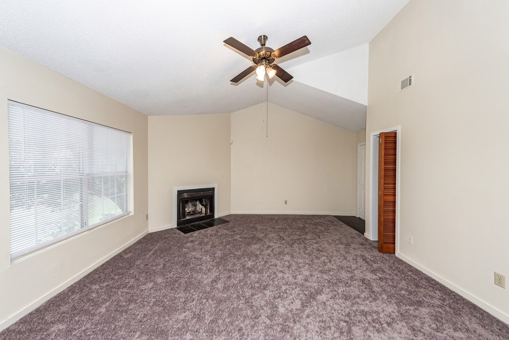 A room with a fireplace and a ceiling fan.