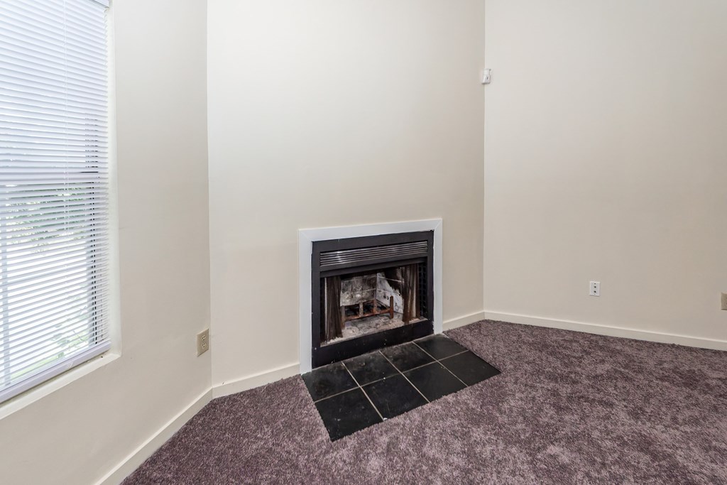 A fireplace in a room with a purple carpet.