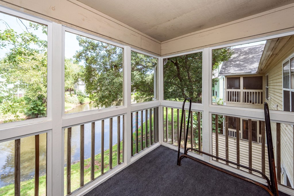 A screened porch with a view of a river.