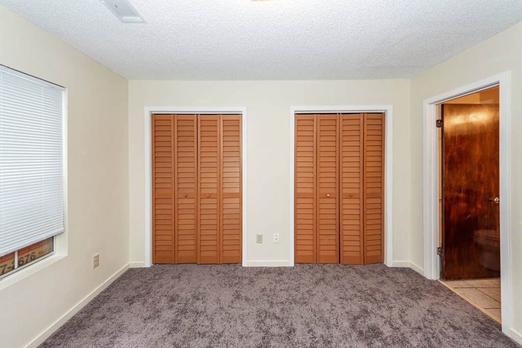 A room with two closets and a door.