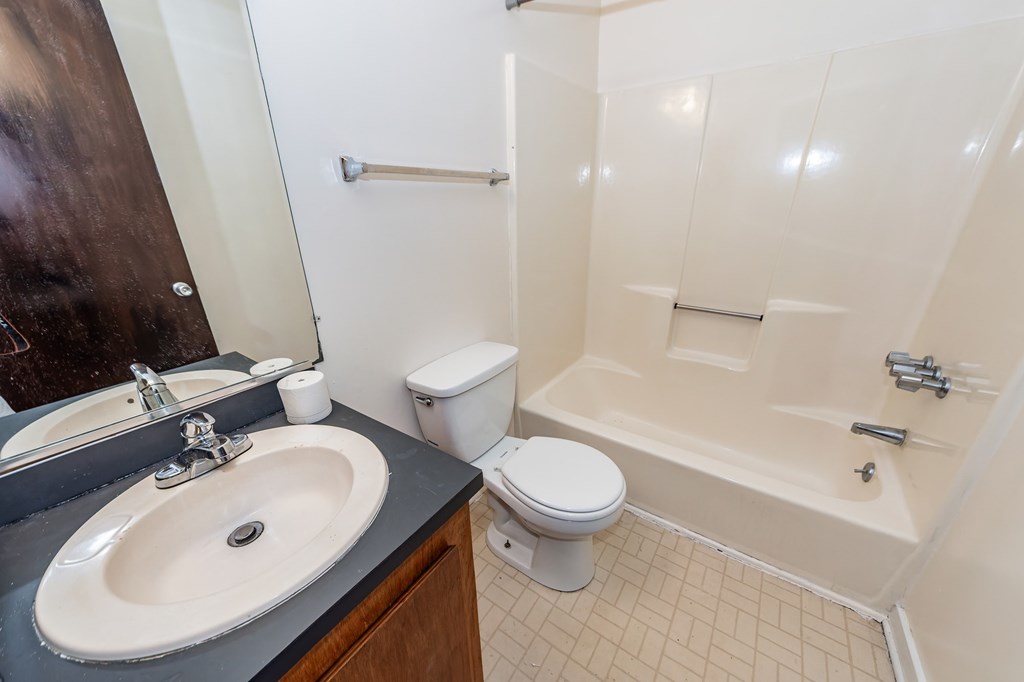 A bathroom with a toilet, sink, and bathtub.