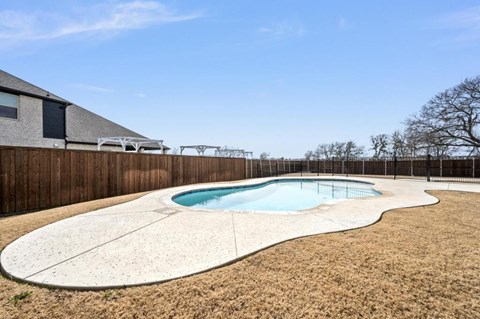A small kidney-shaped pool with a concrete border.