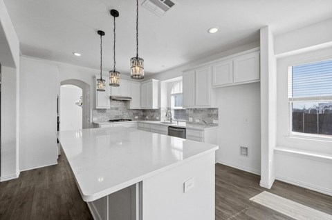 A modern kitchen with white cabinets and a large island.