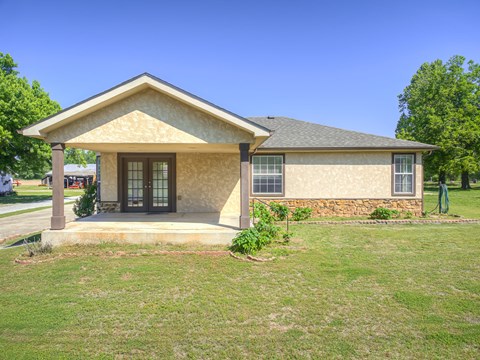 A house with a brown roof and a stone wall in front.