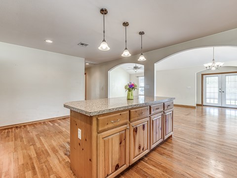 A kitchen with wooden cabinets and a granite countertop.