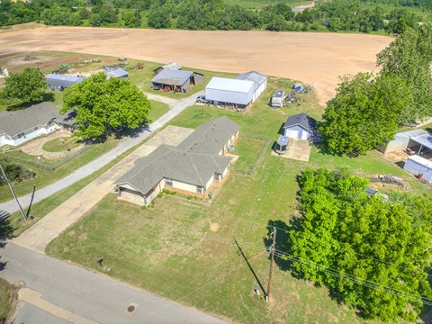 A rural landscape with a few buildings and trees.