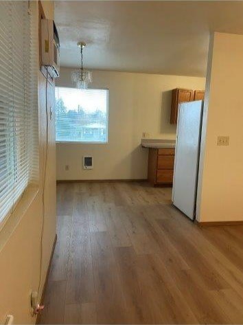 A kitchen with a white refrigerator and wooden floors.