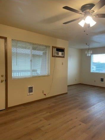 A room with a ceiling fan and wooden flooring.