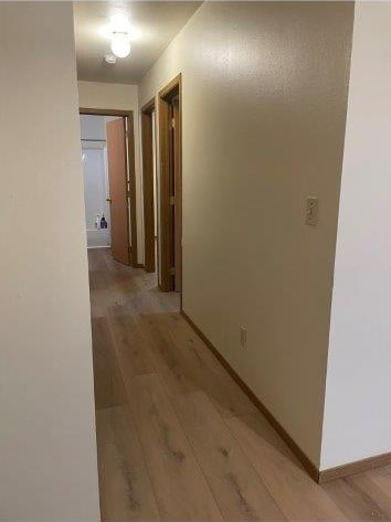 A long hallway with wood floors and white walls.