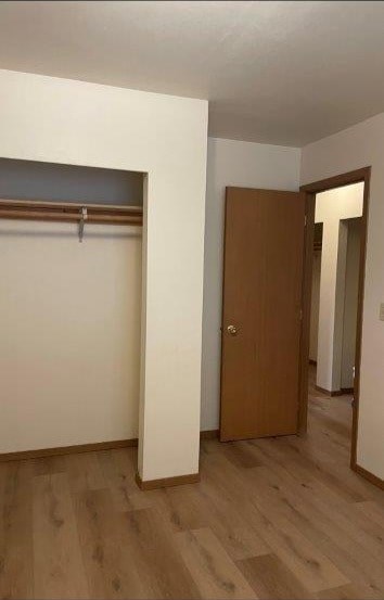 A hallway with a brown door and a white wall.