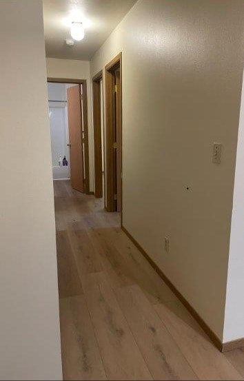 A hallway with wood floors and white walls.