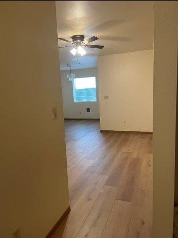 A room with wooden flooring and a ceiling fan.