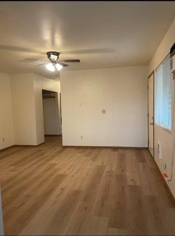 A room with wooden flooring and a ceiling fan.