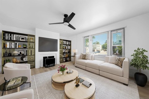 A living room with a white couch, a coffee table, and a fireplace.