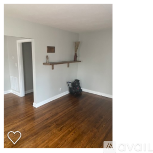 A room with wooden floors and a shelf with a few items on it.